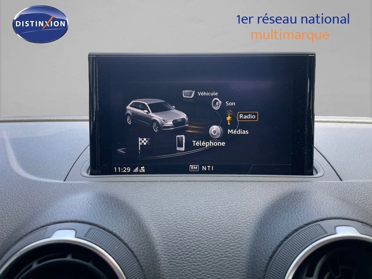 Écran central de l'Audi A3 Sportback 35 TFSI bleu cosmos, affichant le menu multimédia avec options radio et téléphone.