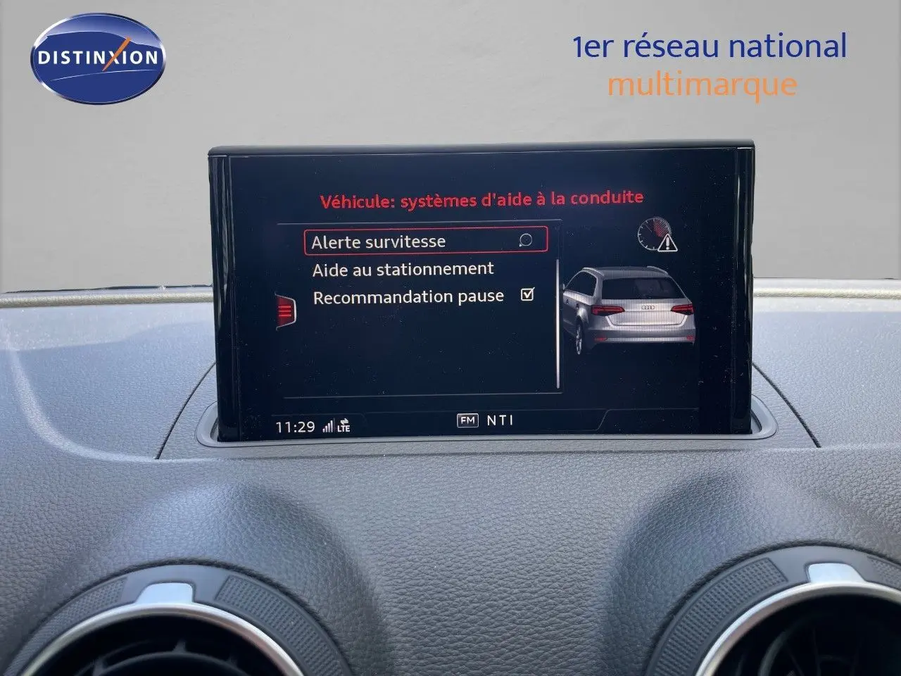 Écran central de l'Audi A3 Sportback 2020 affichant les aides à la conduite avec interface noire et texte rouge et blanc.