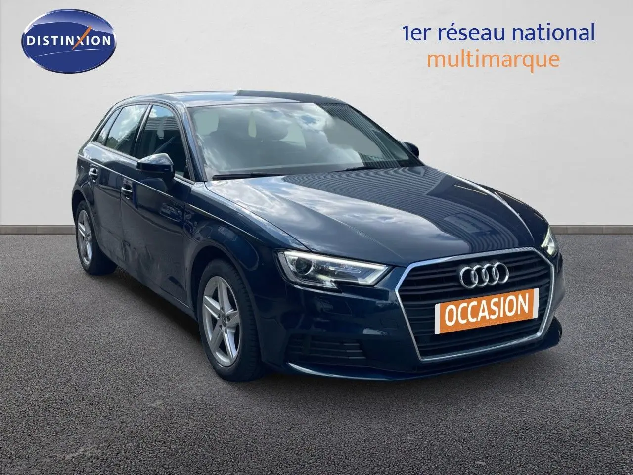 Audi A3 Sportback bleu cosmos métal vue 3/4 avant droit avec calandre hexagonale et phares LED allumés.