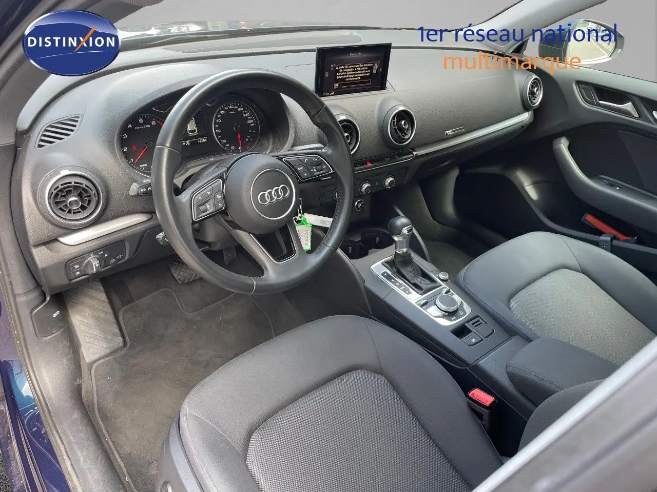 Intérieur de l'Audi A3 Sportback 2020 vu côté conducteur, tableau de bord noir avec écran central et volant multifonction.