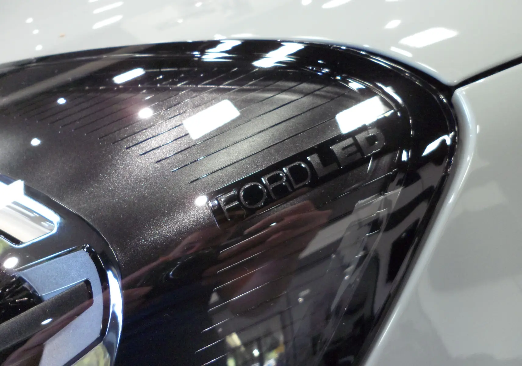 Gros plan sur le feu arrière LED noir brillant du Ford Puma gris Cactus 2025, soulignant son design moderne.