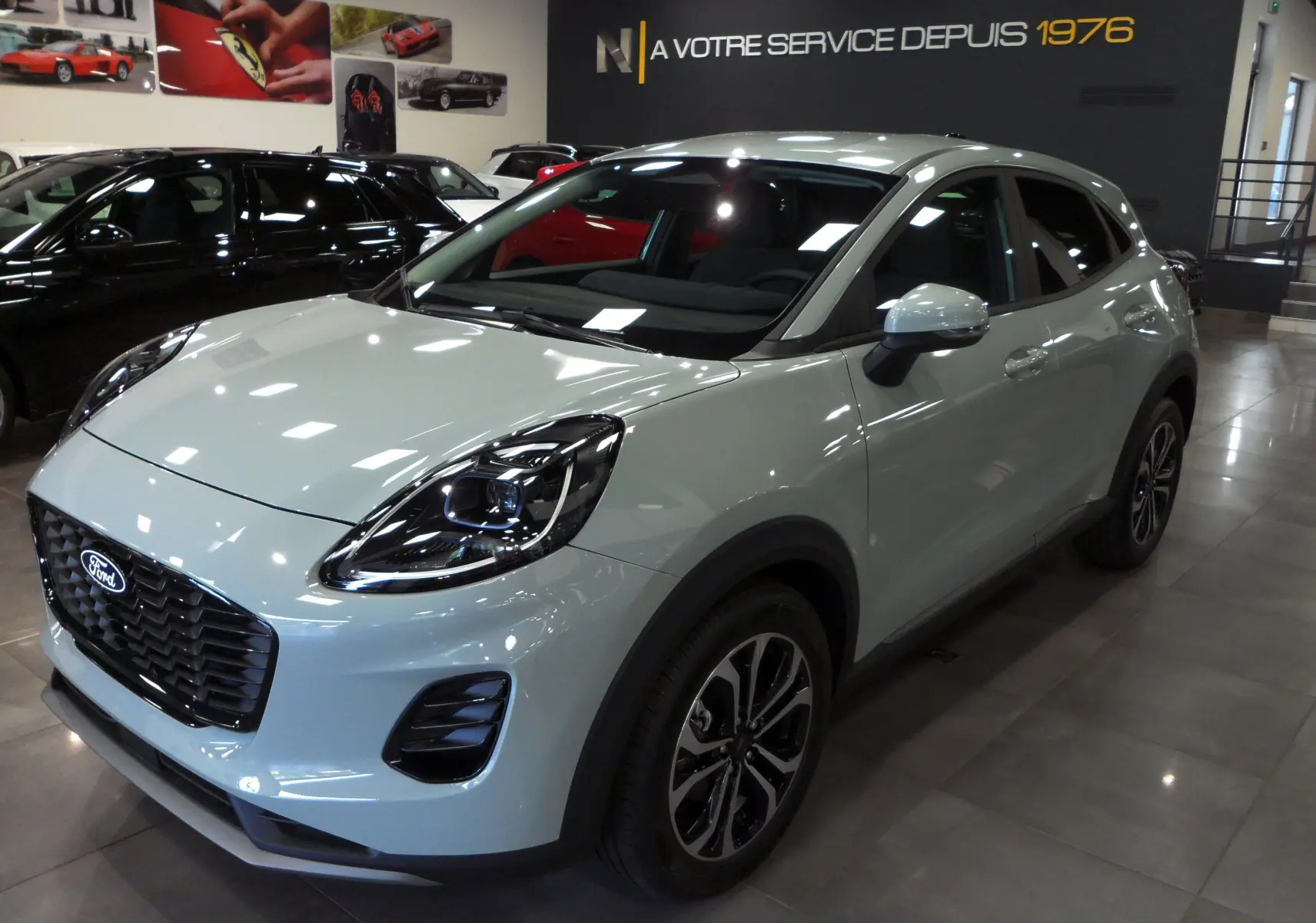 Ford Puma gris Cactus en 3/4 avant droit, avec phares LED et jantes bi-ton 17 pouces en showroom.