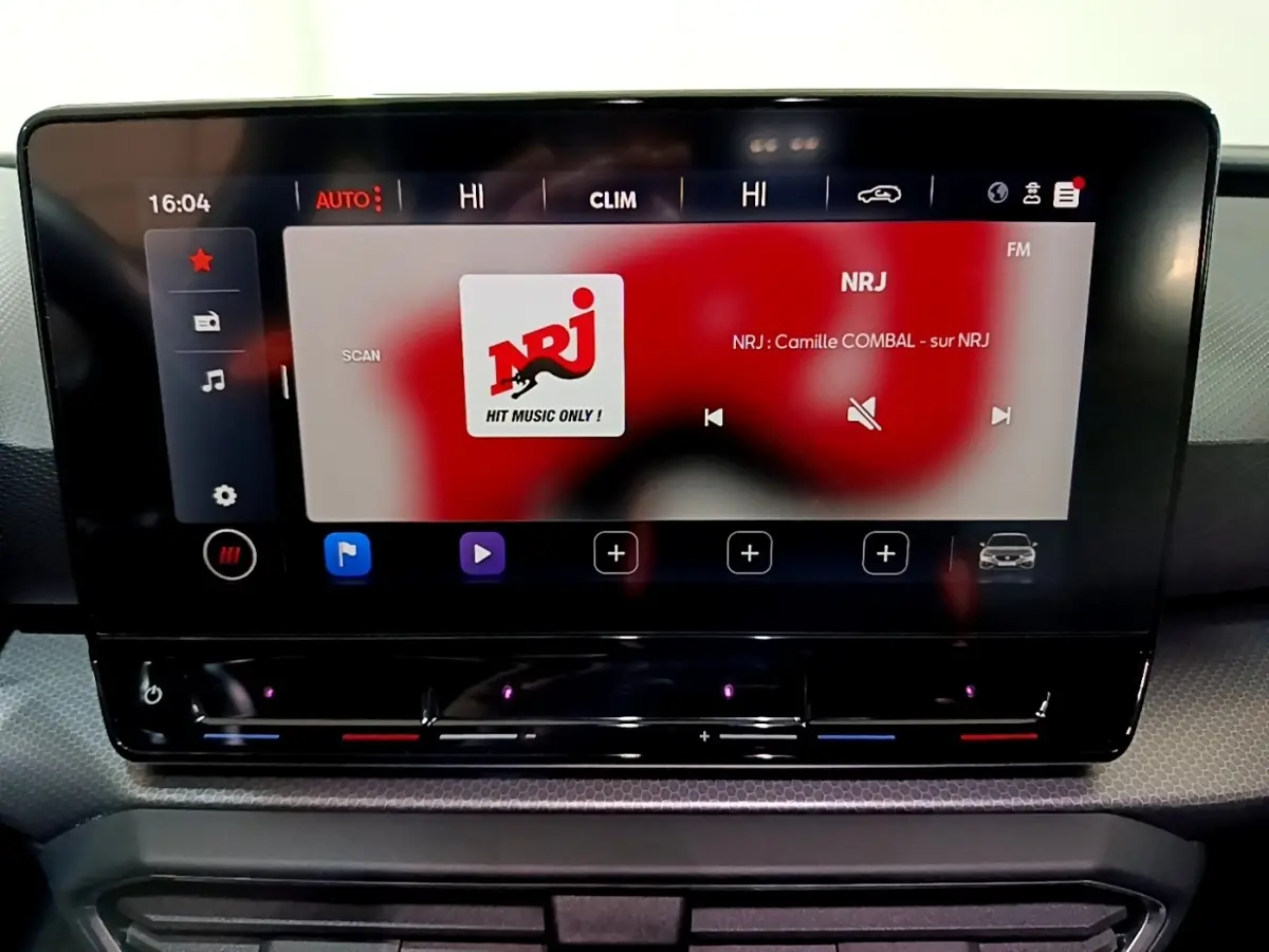 Écran tactile central allumé du tableau de bord de la SEAT Leon 2023, affichant la radio NRJ.