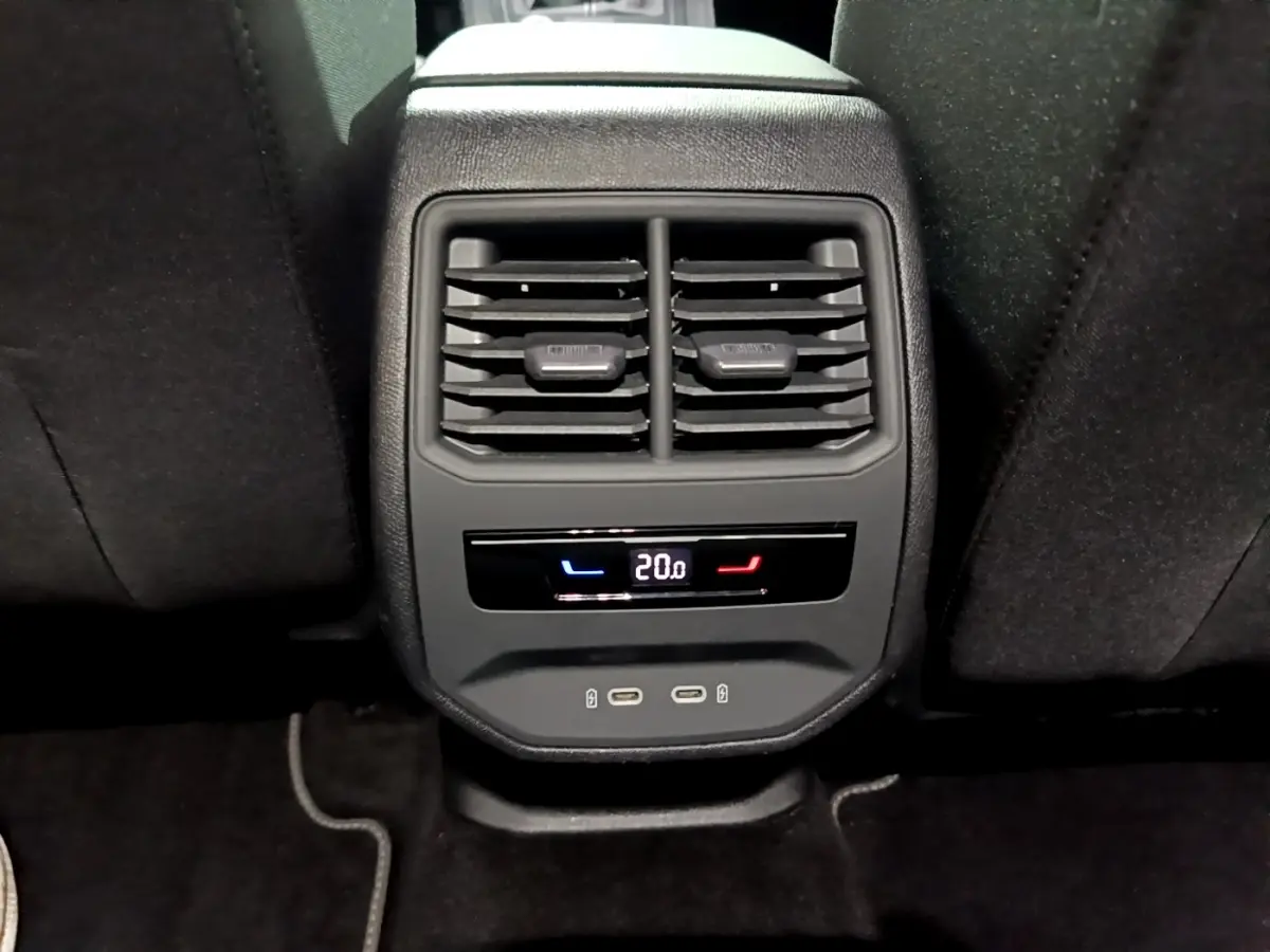 Vue rapprochée de la console arrière avec bouches d’aération, affichage digital de la climatisation et ports USB de la SEAT Leon 2023.