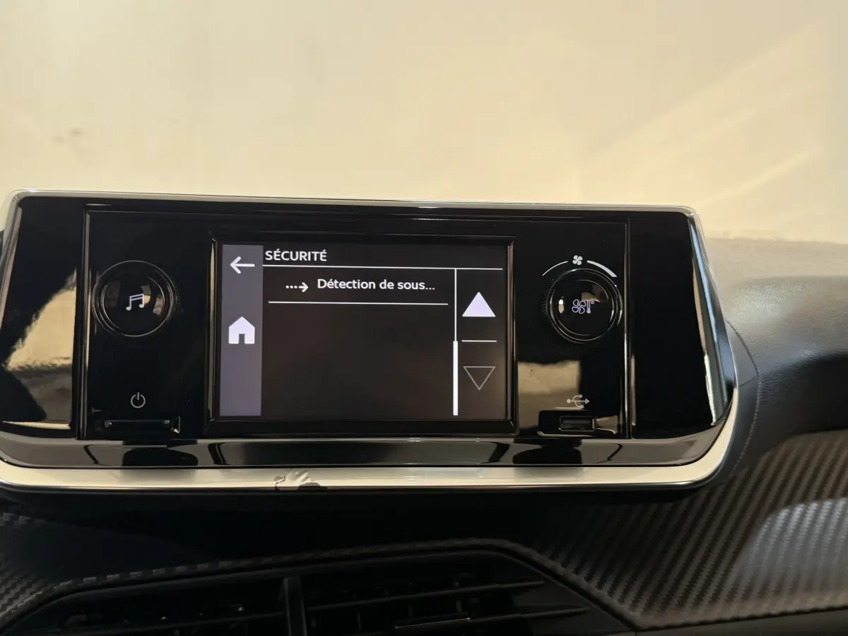 Écran tactile central de la Peugeot 208 PureTech 75 S&S Like affichant le menu sécurité, intérieur noir brillant.