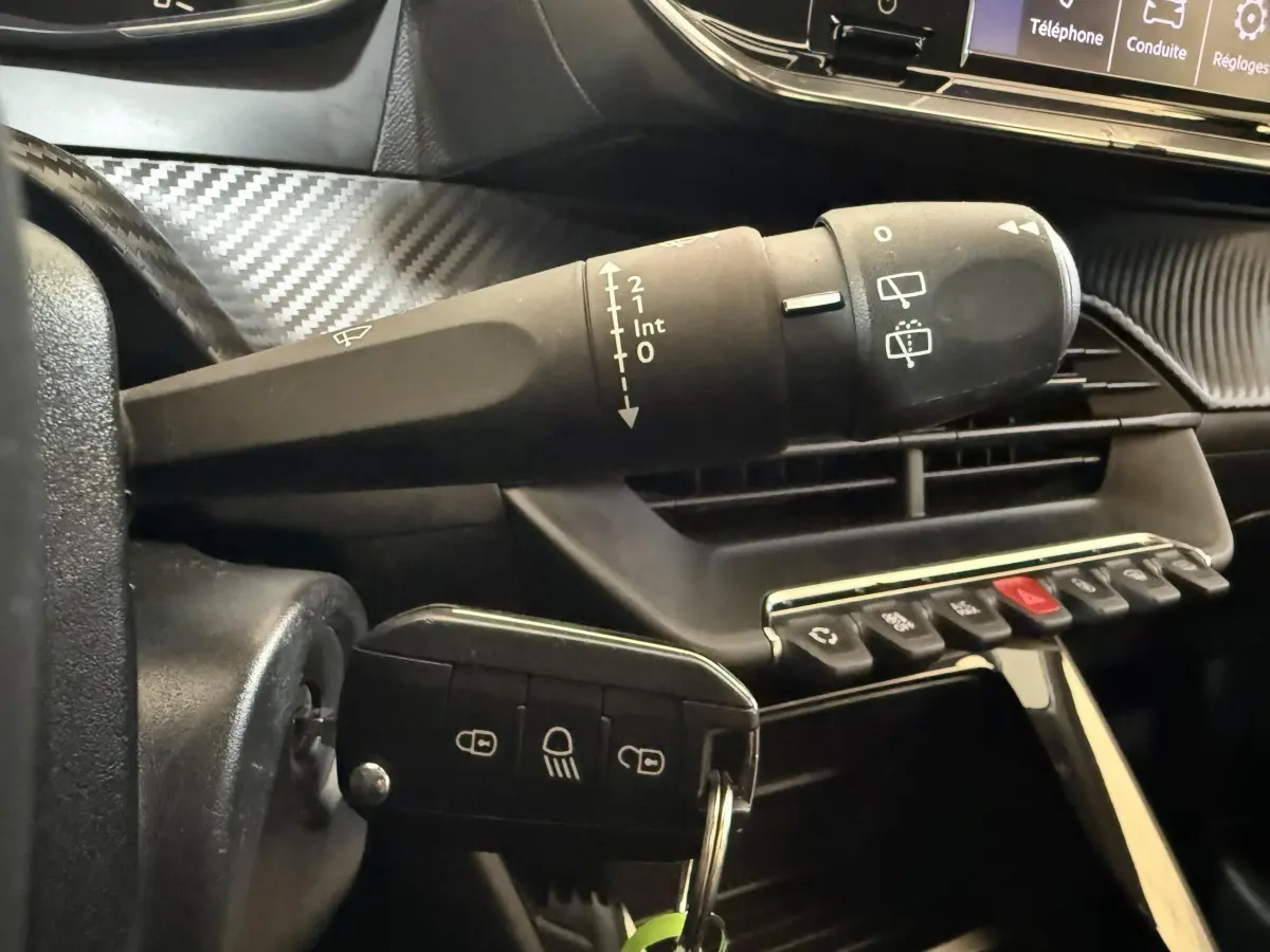 Gros plan sur la commande d’essuie-glace et la clé insérée dans le contacteur d’une Peugeot 208 PureTech 75 S&S Like 2020.