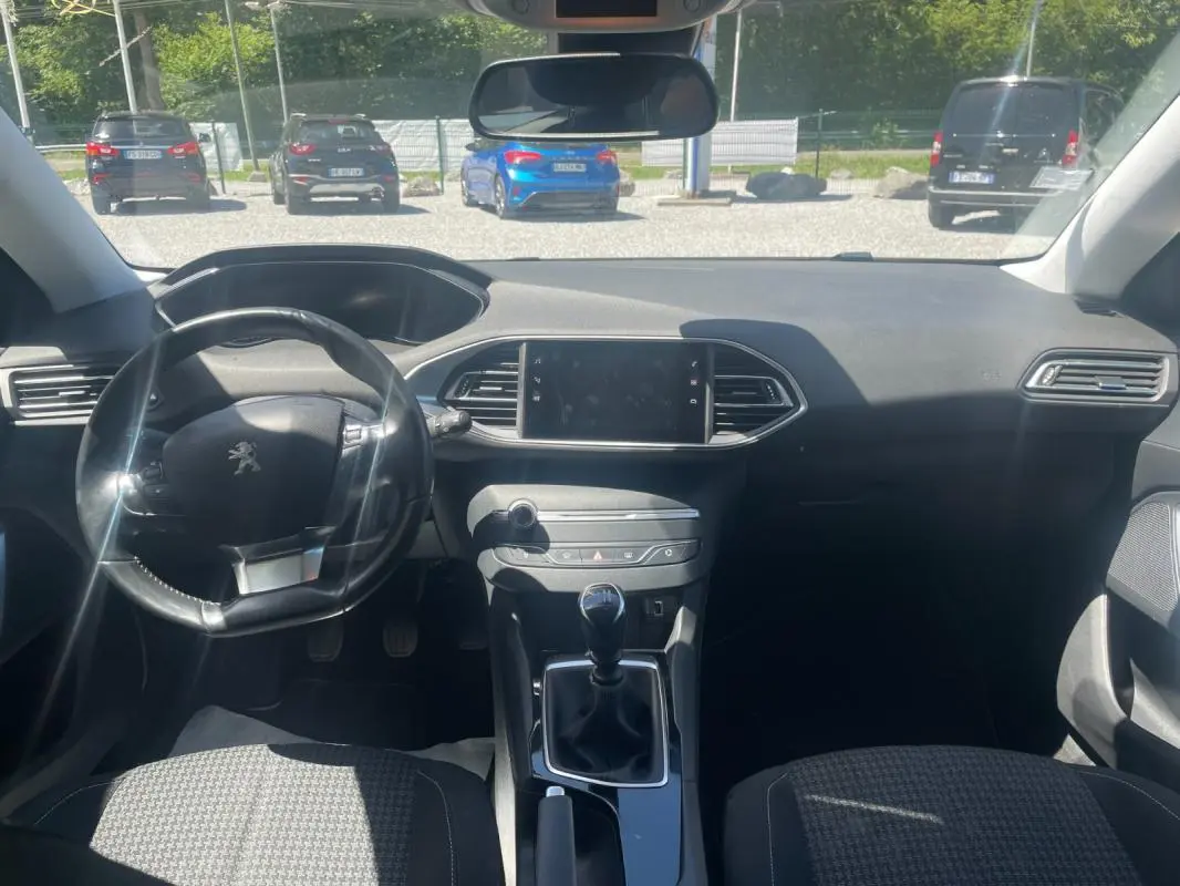 Intérieur de Peugeot 308 2020 vue de face, tableau de bord noir avec volant compact et levier de vitesse manuel.