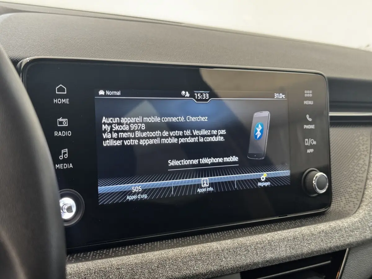 Écran tactile central allumé du tableau de bord d’une Skoda Scala gris clair, affichant la connexion Bluetooth.