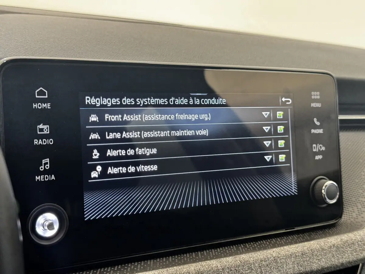 Écran tactile central de la Skoda Scala gris clair affichant les réglages d'aide à la conduite.