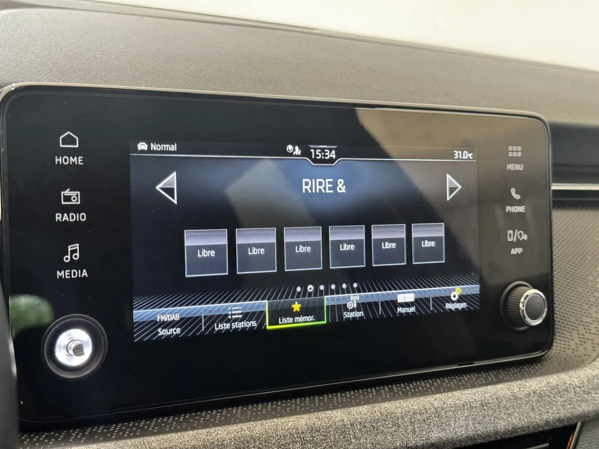Écran tactile central de 21 cm du Skoda Scala 2025, affichant les options radio avec commandes autour.
