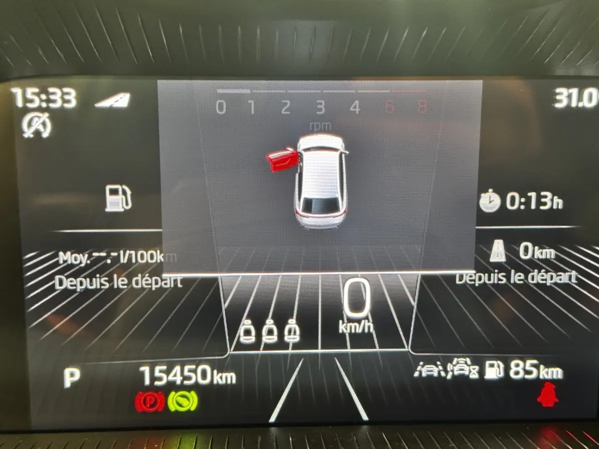Affichage numérique du combiné d'instruments d'une Skoda Scala gris clair, montrant porte avant gauche ouverte et vitesse à 0 km/h.