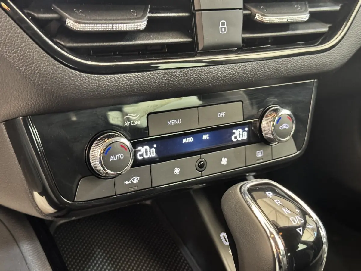 Gros plan sur la console centrale noire de la Skoda Scala 2025, montrant la climatisation automatique et le levier de vitesse.