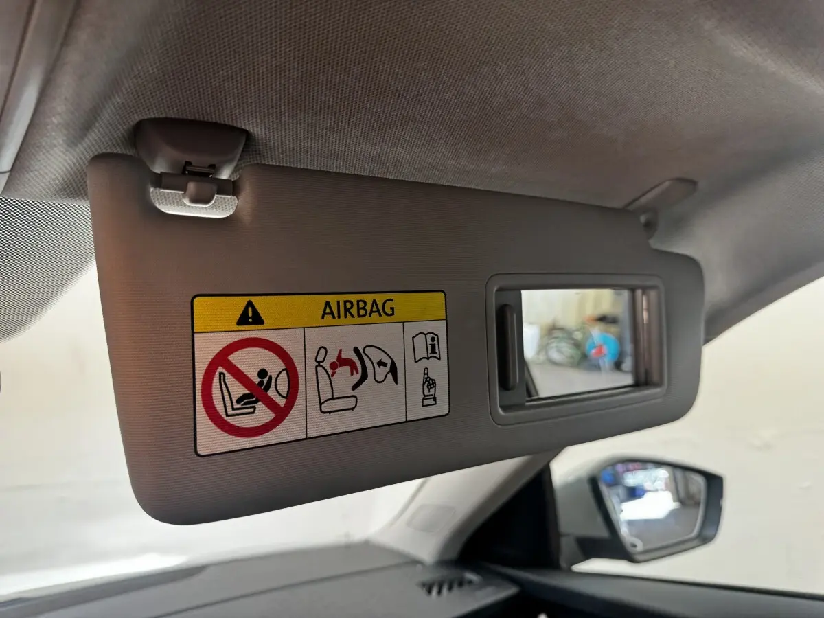 Détail du pare-soleil côté conducteur avec miroir et avertissement airbag dans une Skoda Scala gris clair.
