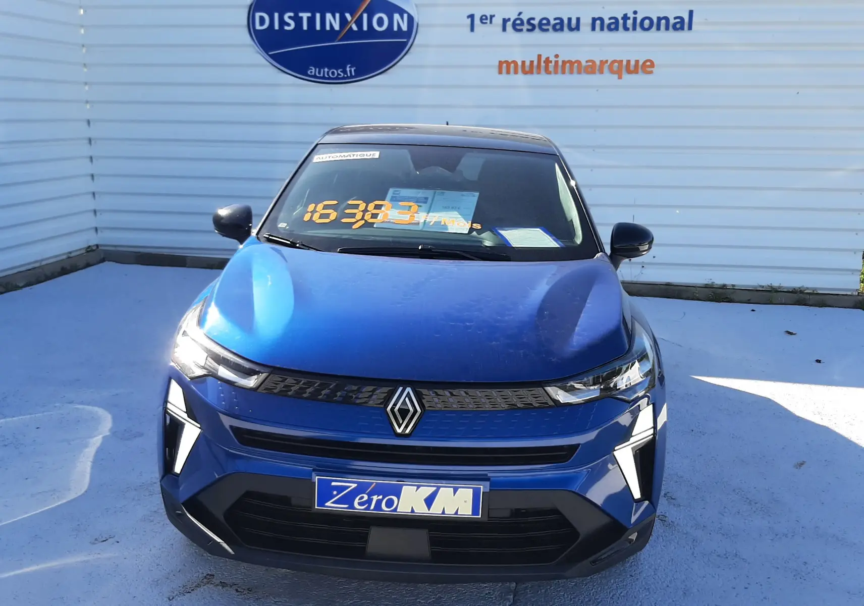 Vue avant d'un Renault Captur E-Tech Hybrid 145ch bleu Iron avec toit noir, phares LED et calandre moderne.