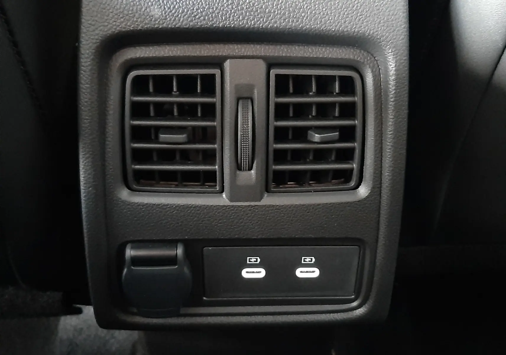 Vue rapprochée des aérateurs arrière et des ports USB du Renault Captur E-Tech Hybrid 2024 avec intérieur noir.