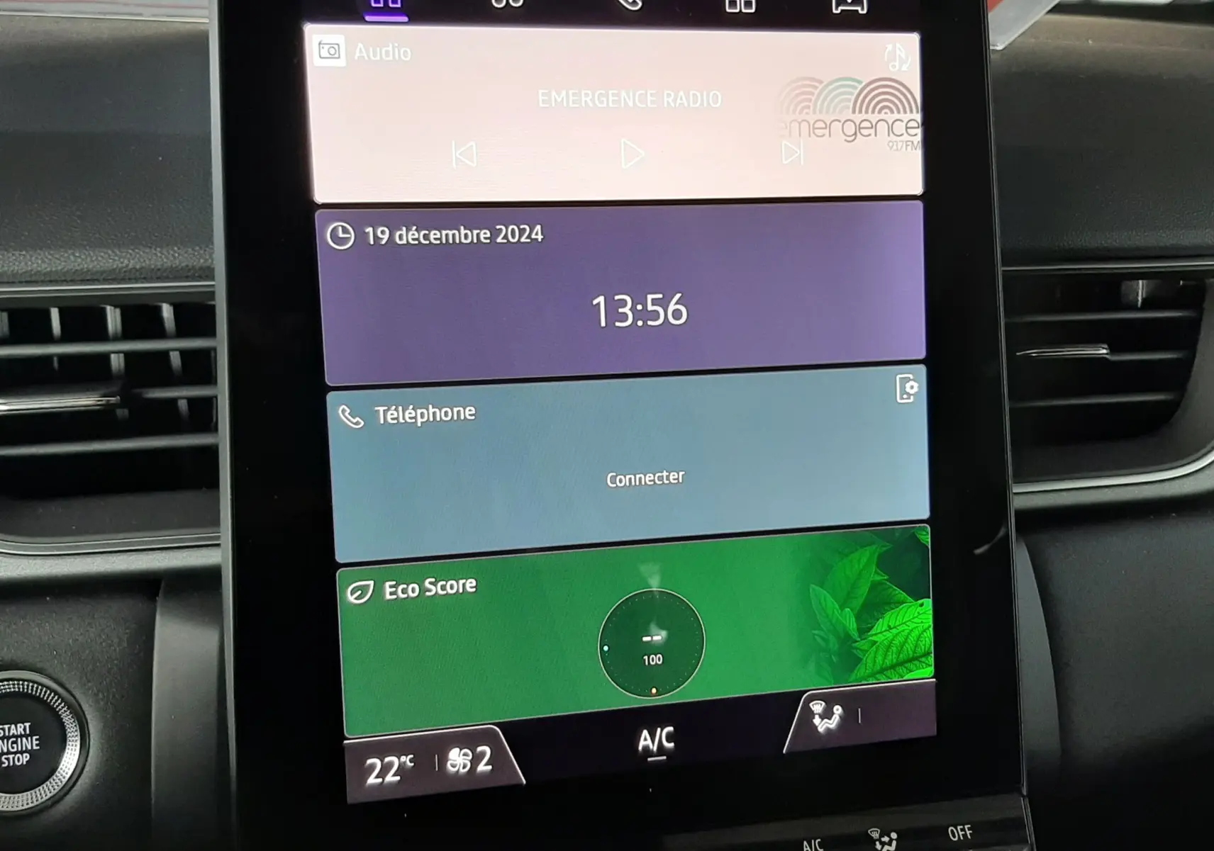 Écran tactile central du tableau de bord du Renault Captur E-Tech Hybrid 2024 affichant radio, téléphone et score écologique.