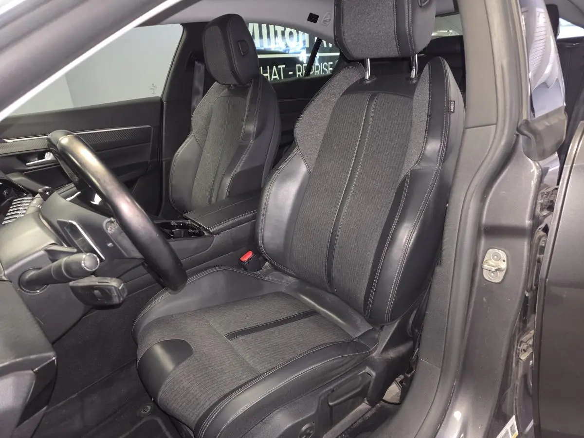 Intérieur côté conducteur d'une Peugeot 508 gris, siège tissu et cuir noir avec volant compact multi-fonctions visible.