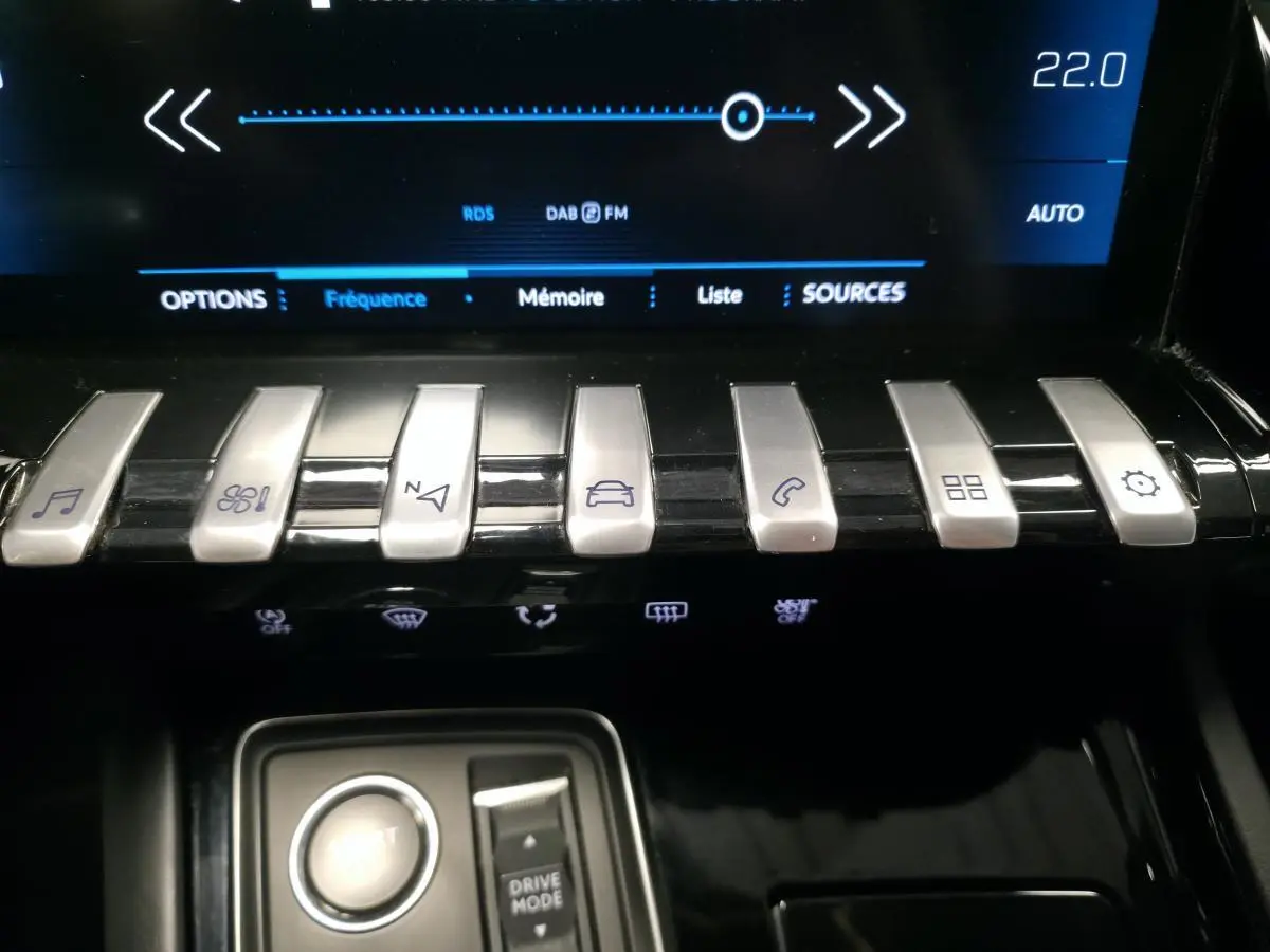 Console centrale avant de Peugeot 508 gris 2018 avec touches piano chromées et écran tactile affichant la radio