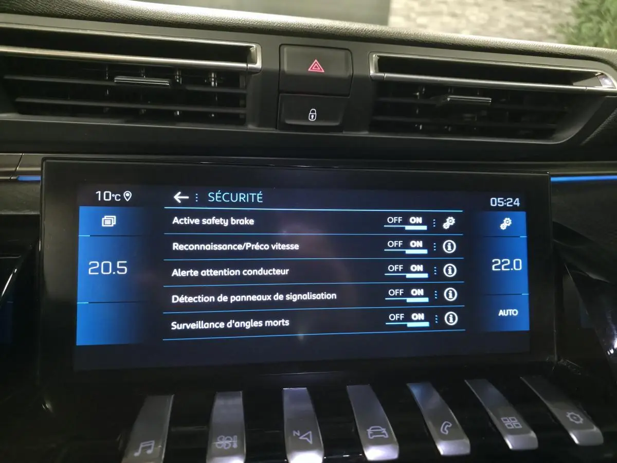 Écran tactile central de la Peugeot 508 gris montrant les réglages de sécurité avec commandes piano en bas.