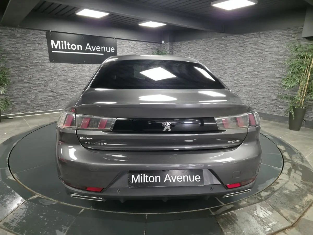Vue arrière d'une Peugeot 508 gris métallisé avec feux arrière à trois griffes et double sortie d'échappement chromée.