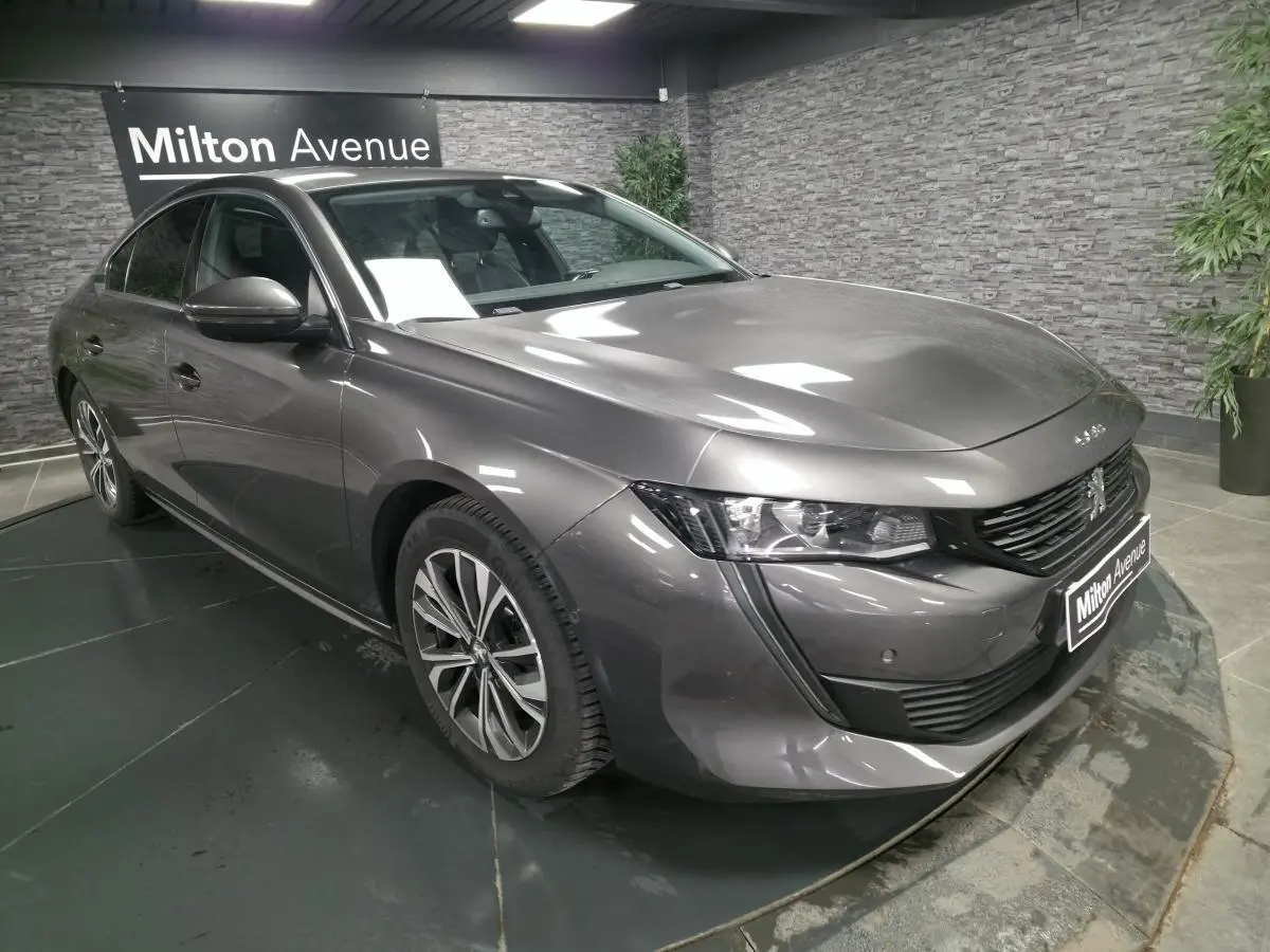 Peugeot 508 gris métallisé vue 3/4 avant droit avec calandre noire et jantes alliage 17 pouces.