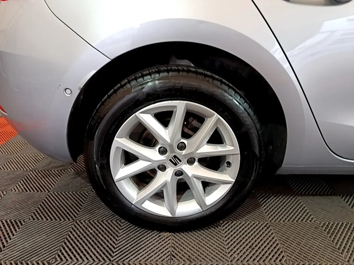 Gros plan sur la roue arrière droite gris foncé d'une SEAT LEON 2023 avec jante alliage et logo central visible.