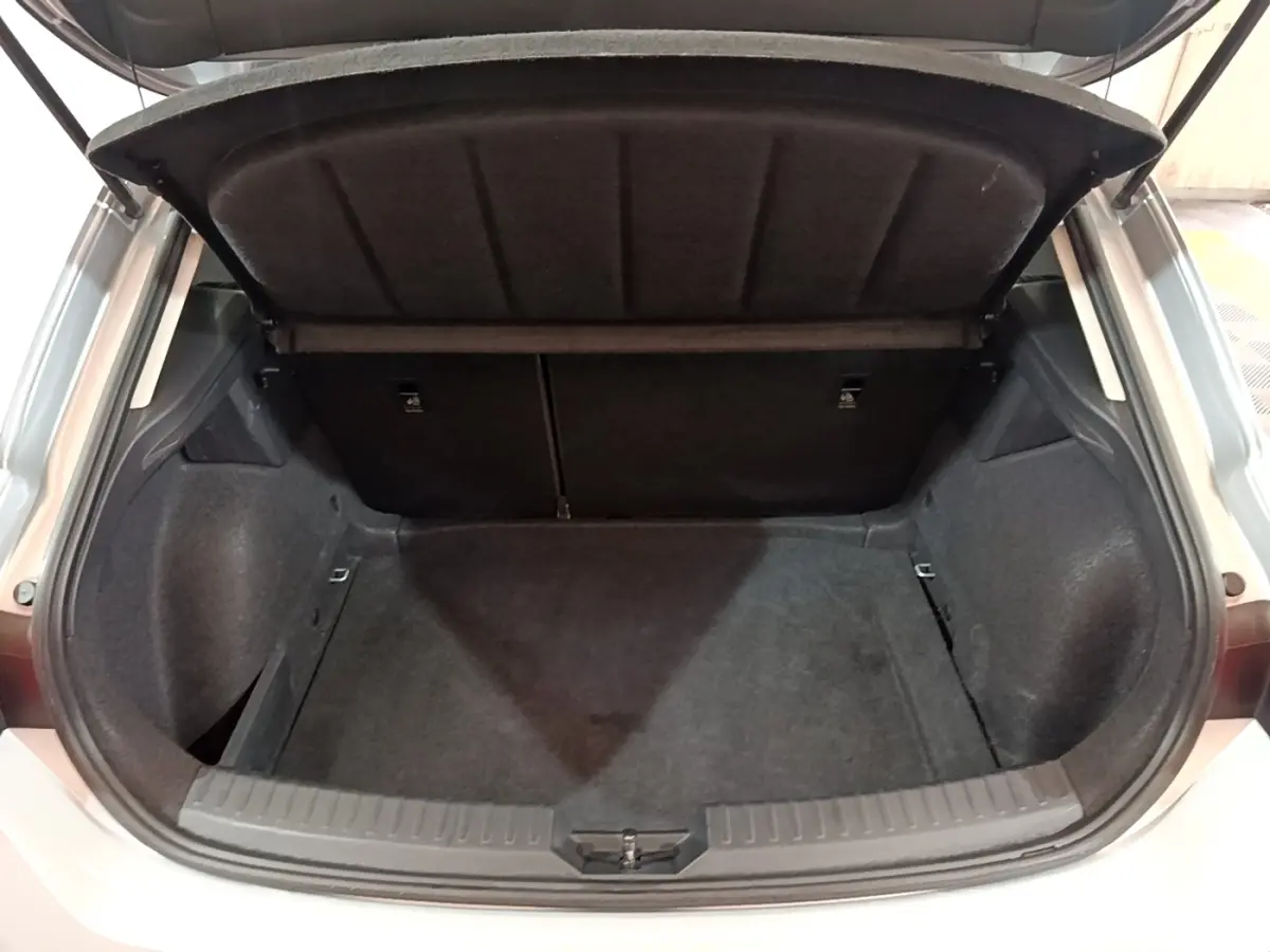 Coffre ouvert vu de l'arrière d'une SEAT Leon gris foncé, montrant un espace de chargement propre et spacieux.