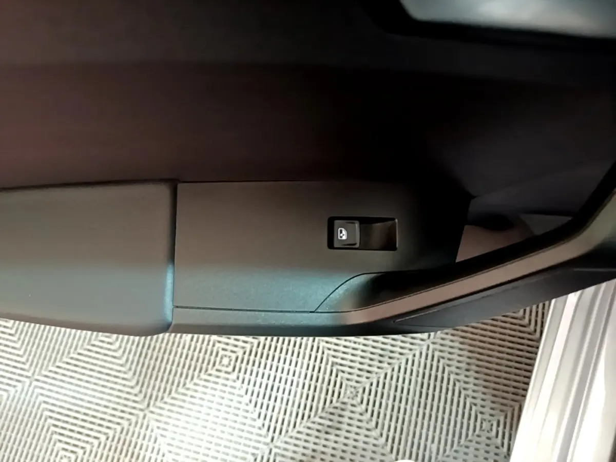 Bouton de déverrouillage de coffre sur la porte côté gauche d'une SEAT LEON gris foncé 2023 vue en gros plan intérieur