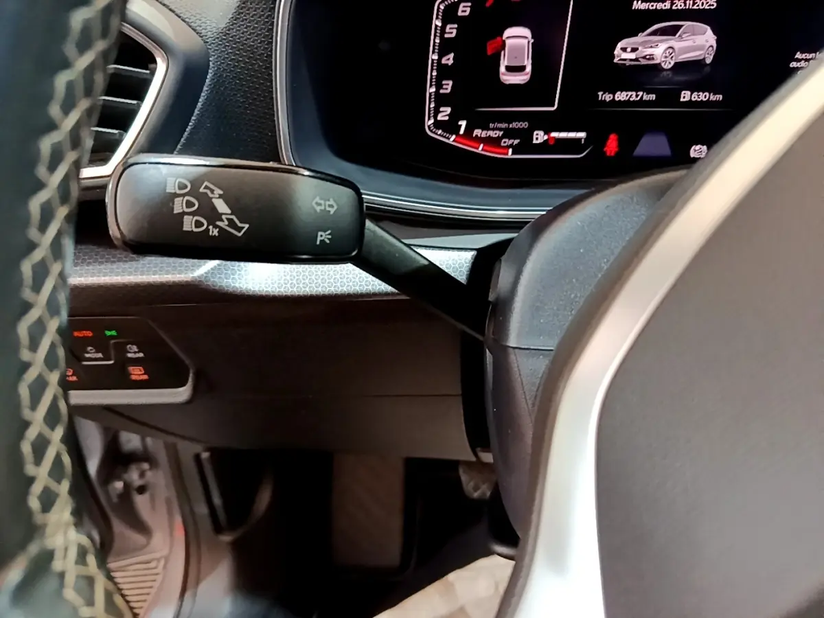 Gros plan sur la manette de clignotants à gauche du volant dans l’habitacle du SEAT Leon gris foncé 2023.