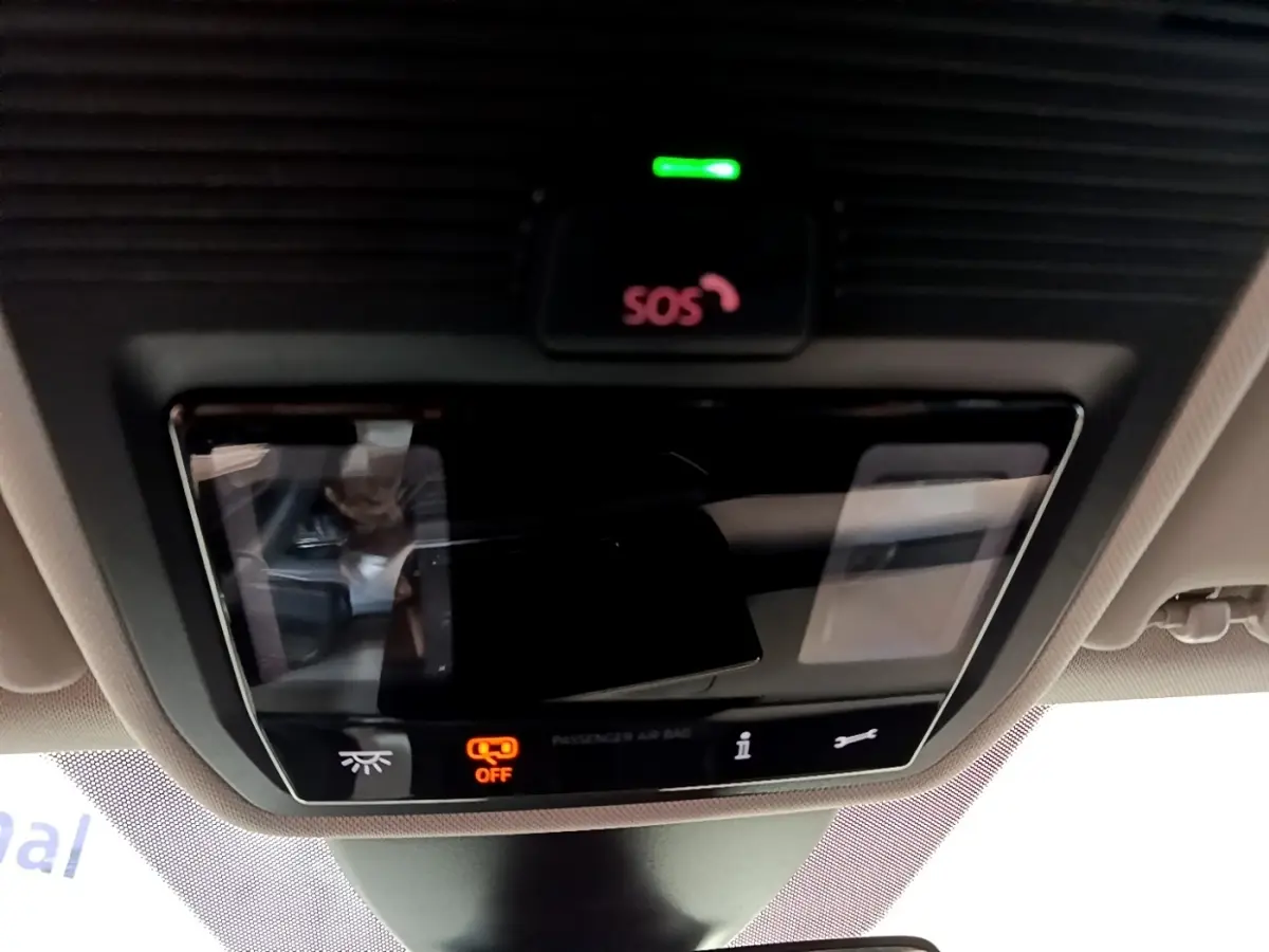 Gros plan sur le panneau de commandes au plafond du SEAT Leon gris foncé, avec bouton SOS et indicateur airbag passager éteint.