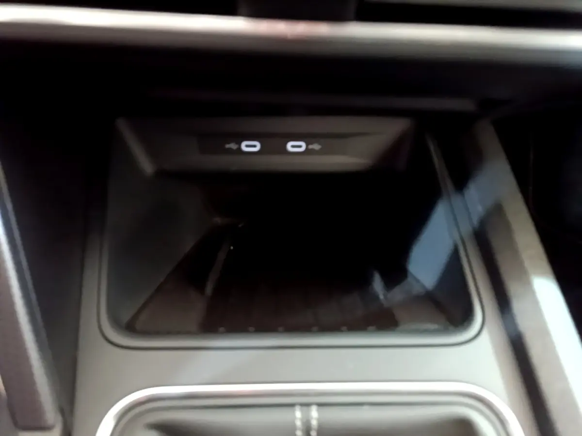Zone de recharge par induction avec deux ports USB-C éclairés, console centrale d'une SEAT Leon gris foncé 2023.