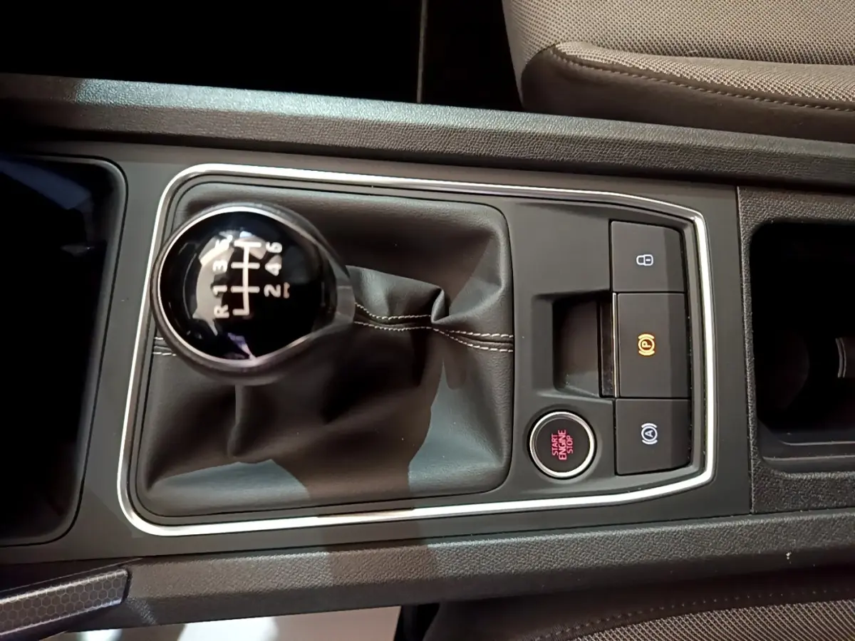 Vue rapprochée de la console centrale grise avec levier de vitesse manuel et bouton start/stop du SEAT Leon 2023.