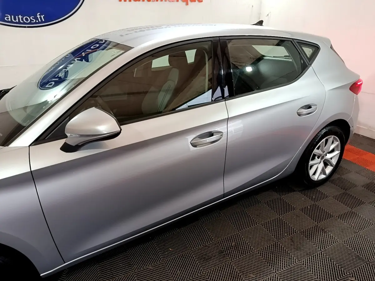 Profil côté gauche d'une SEAT Leon gris foncé 2023, mettant en valeur les lignes épurées et les jantes alliage.