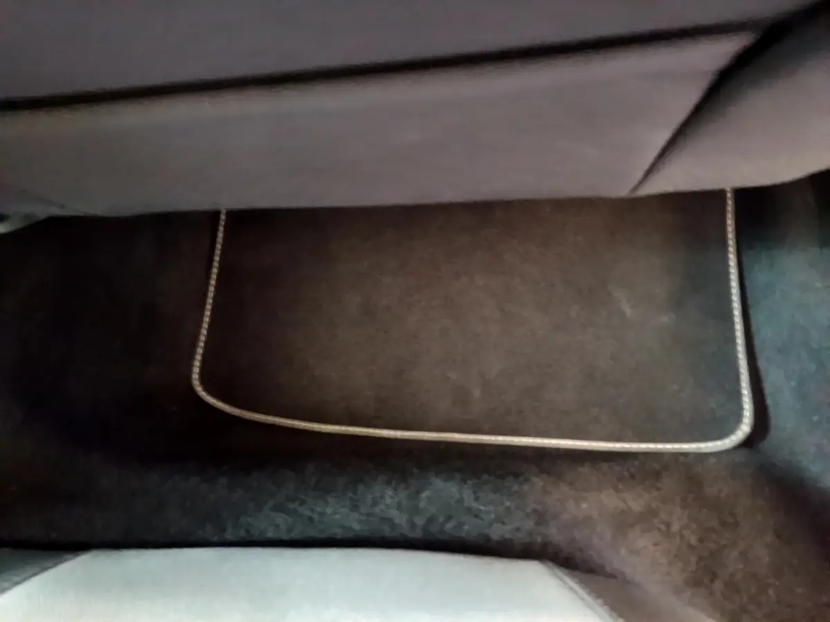 Tapis de sol noir avec surpiqûres claires dans l'habitacle arrière d'une SEAT Leon gris foncé 2023.