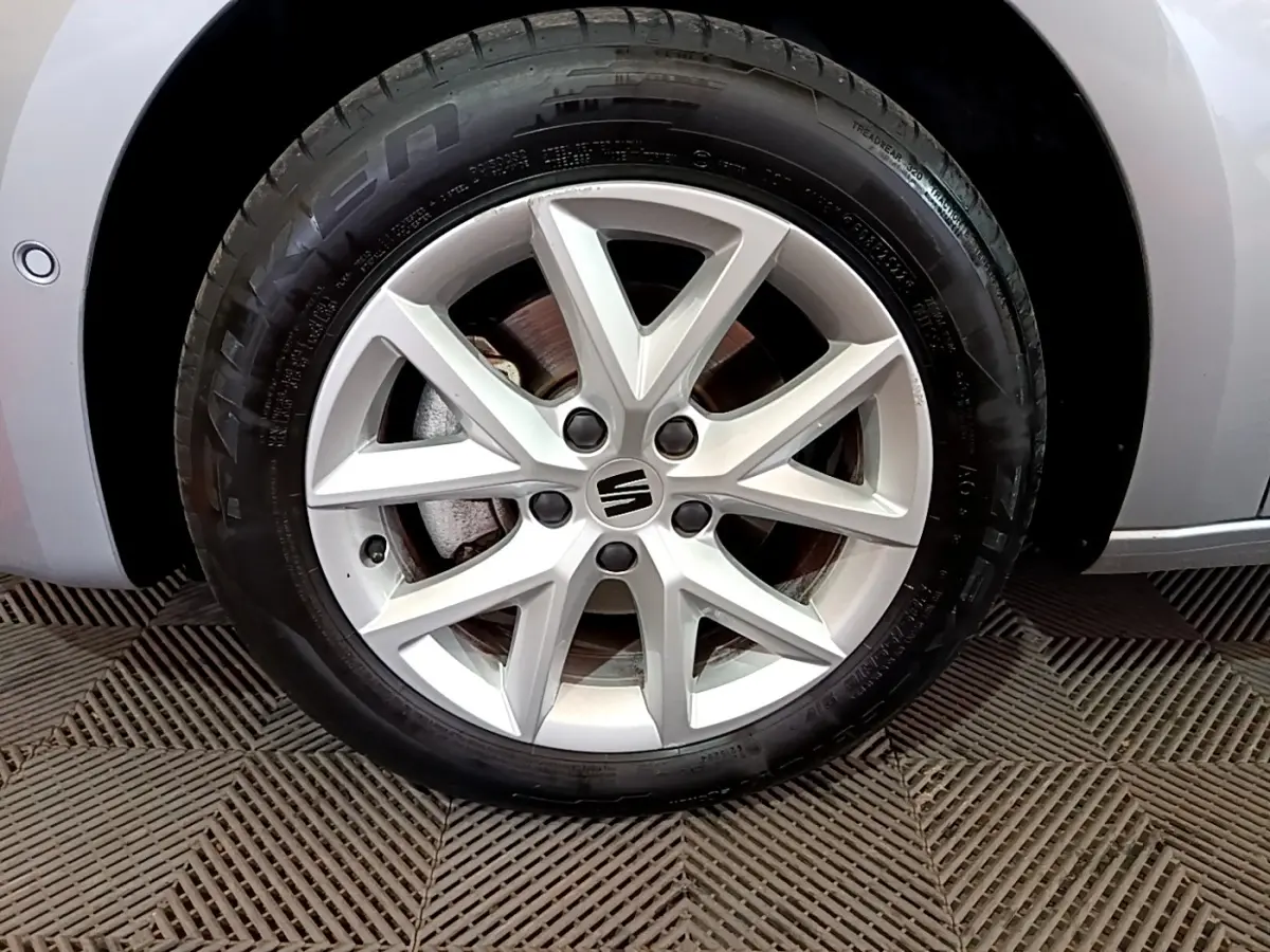 Gros plan sur la roue avant droite gris foncé d'une SEAT LEON 2023 avec jante alliage à 5 doubles branches.