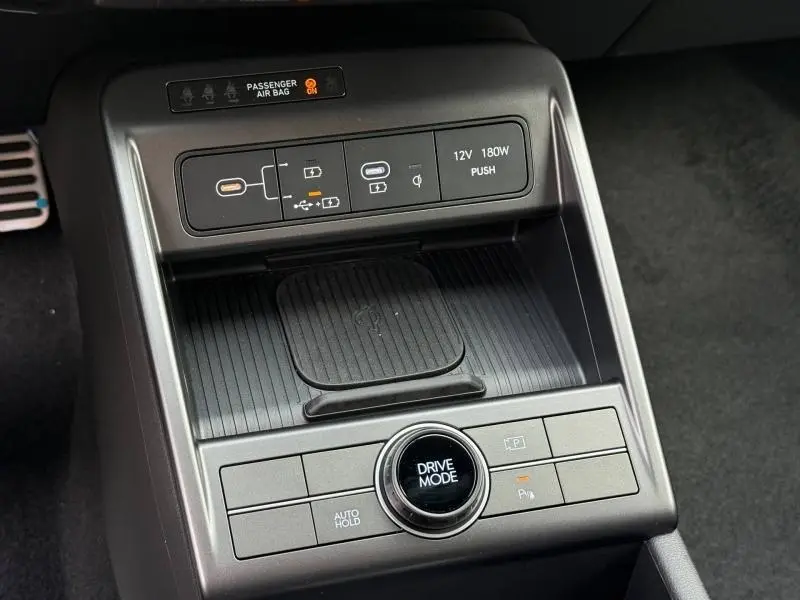 Gros plan sur la console centrale du Hyundai Kona 2025, avec commandes Drive Mode et ports USB visibles.
