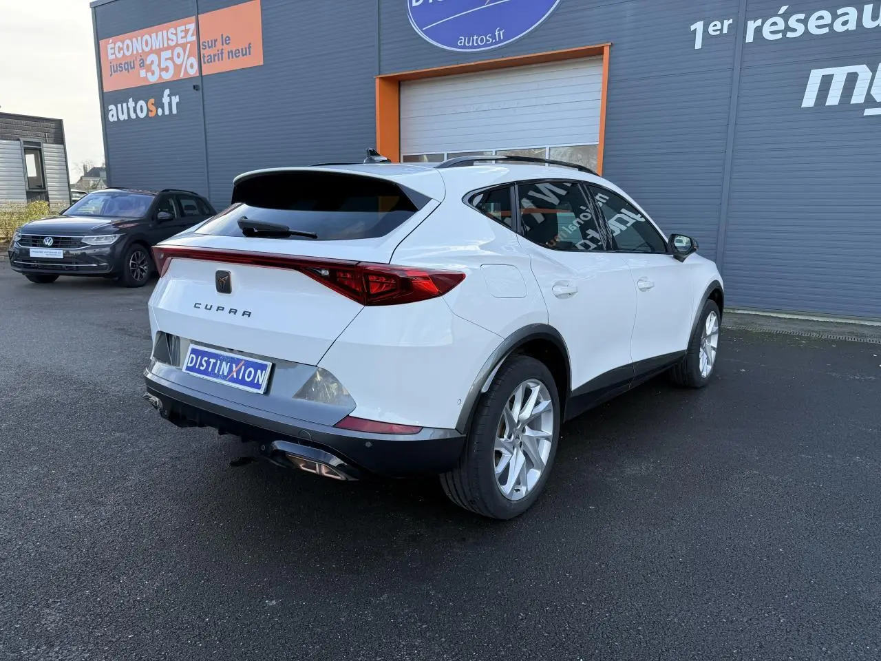 Vue 3/4 arrière droite d'un CUPRA Formentor blanc 2023 avec bandeau LED arrière Infinite Light et jantes alliage 18 pouces.