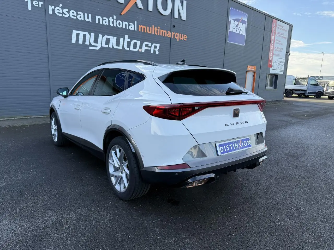 Vue 3/4 arrière droite d'un CUPRA Formentor blanc 2023 avec bandeau LED arrière et jantes alliage 18 pouces.