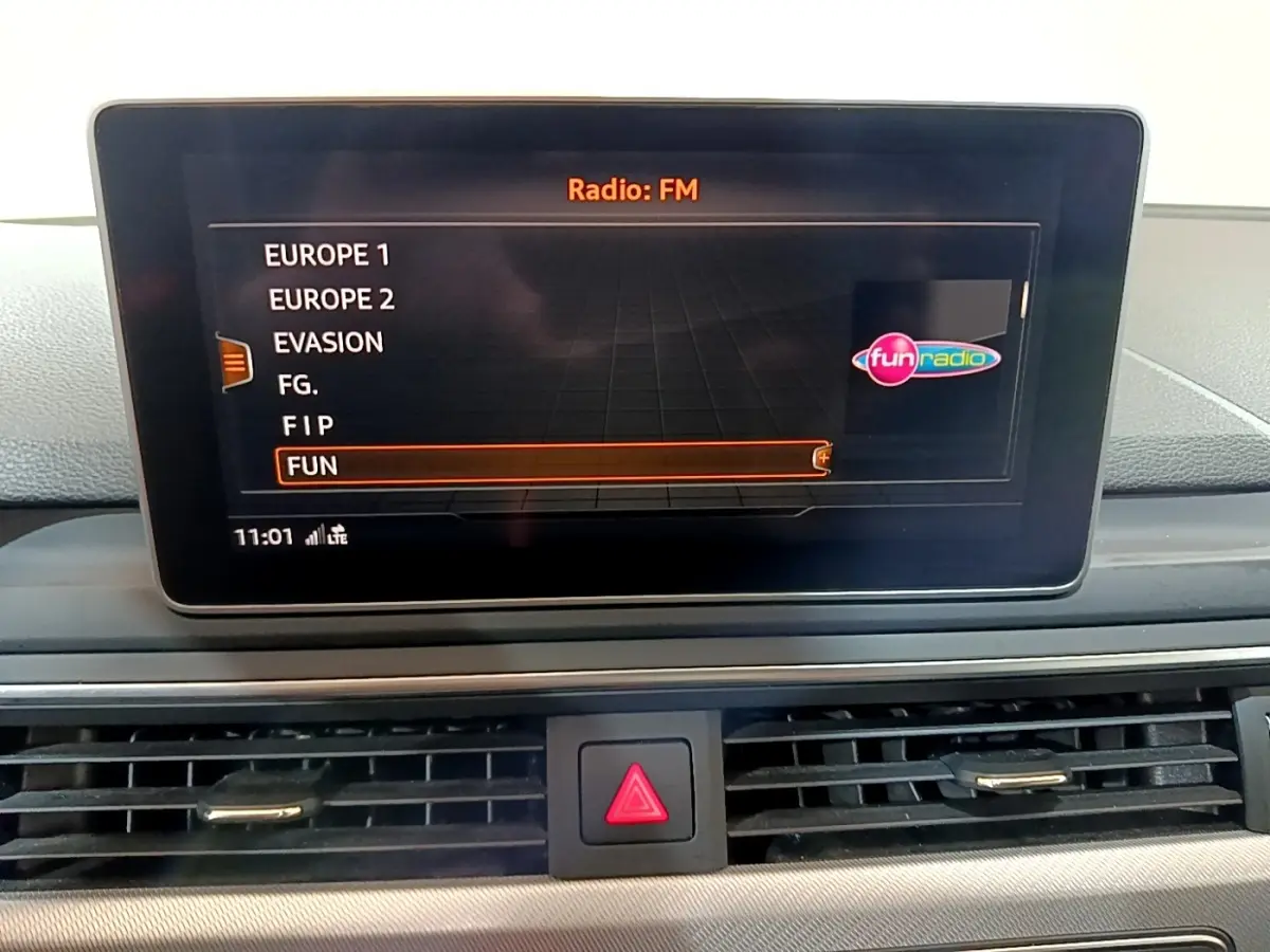Écran tactile central de l'Audi A4 40 TDI 2018 affichant la liste des radios FM, intérieur noir.