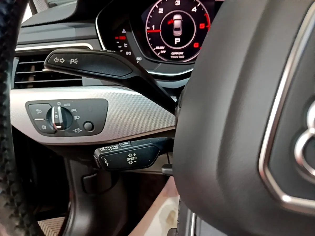 Gros plan sur le volant cuir noir et le tableau de bord numérique rouge de l'Audi A4 40 TDI 2018 côté conducteur.