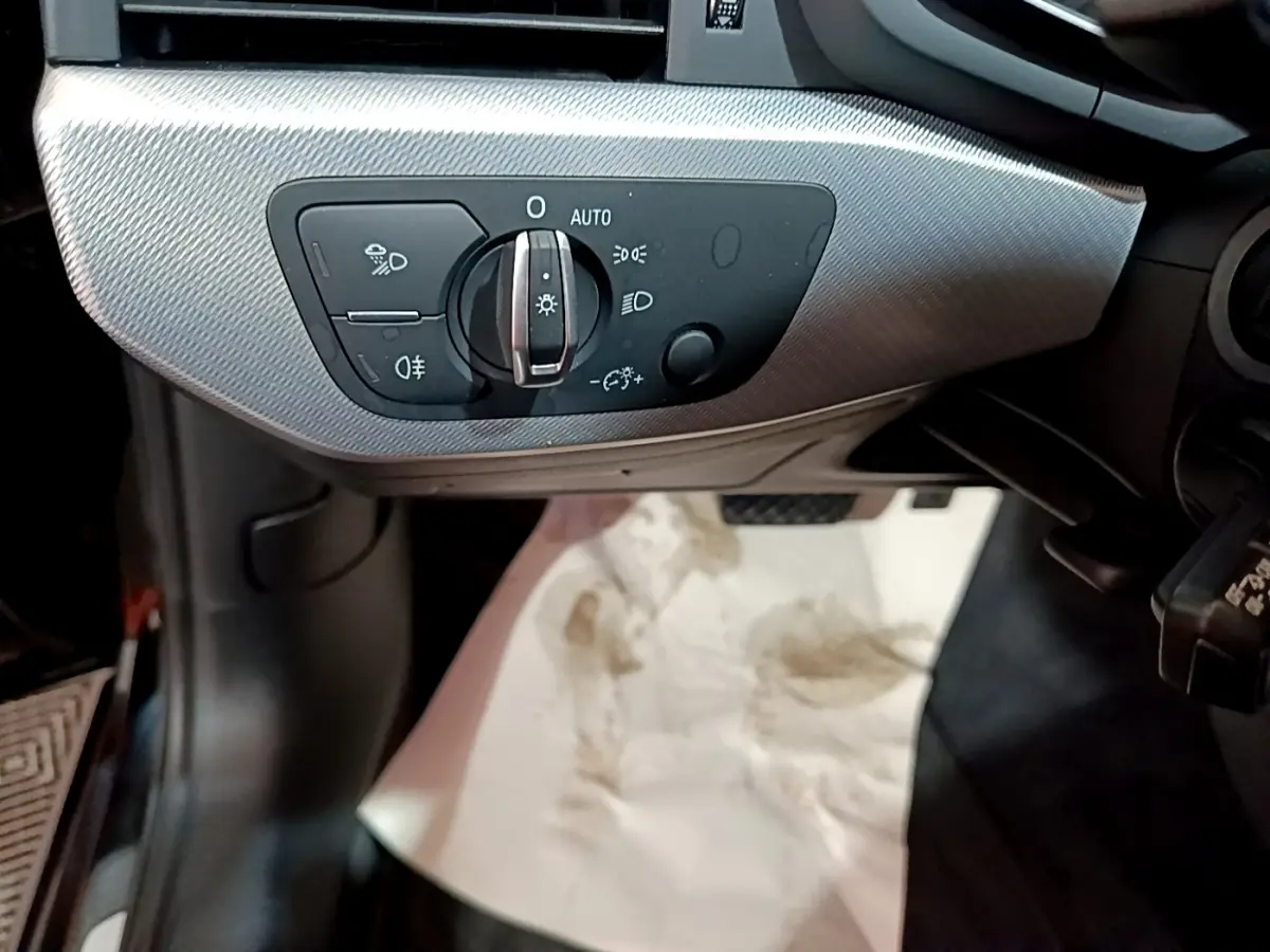 Gros plan sur la commande des phares à gauche du volant dans l'habitacle noir de l'Audi A4 40 TDI 2018.