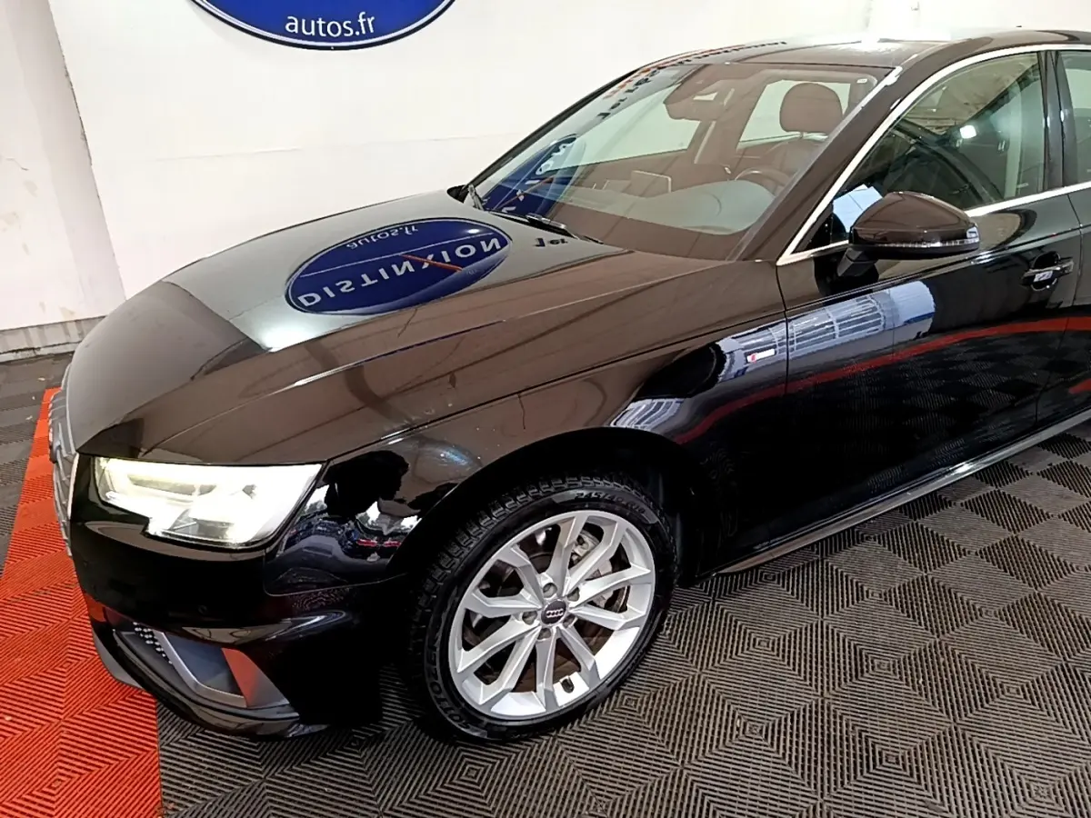 Audi A4 noire vue en 3/4 avant droit, mettant en valeur ses phares LED et jantes alliage argentées.