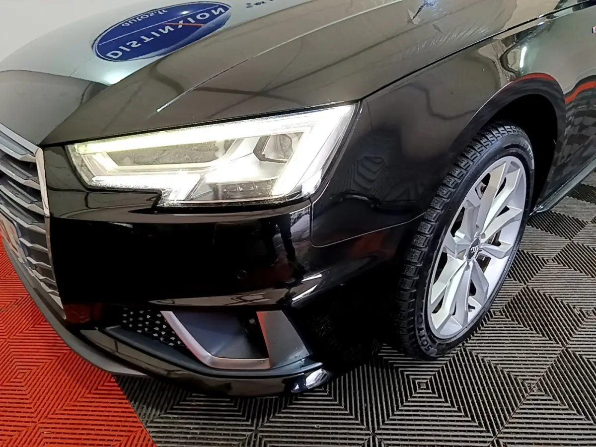 Gros plan sur l'avant droit noir d'une Audi A4 40 TDI 2018, mettant en valeur le phare LED et la jante alu.