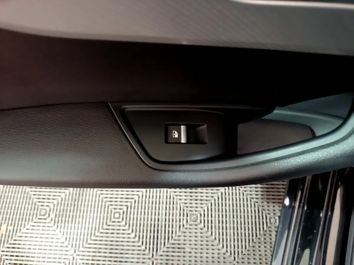 Gros plan sur la commande de verrouillage de porte côté gauche de l'Audi A4 noire, intérieur en cuir noir.