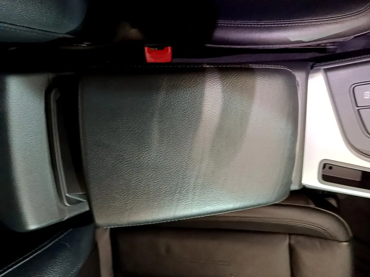 Gros plan sur l'accoudoir central noir en cuir et la console argentée de l'Audi A4 40 TDI 2018 côté conducteur.