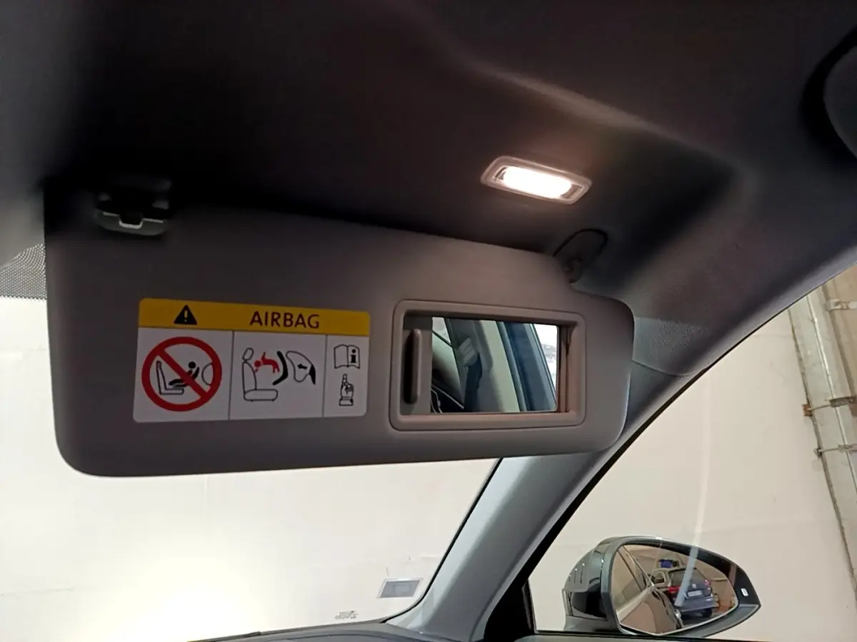 Miroir de courtoisie sur pare-soleil côté conducteur de l'Audi A4 noire, intérieur éclairé, rétroviseur visible.