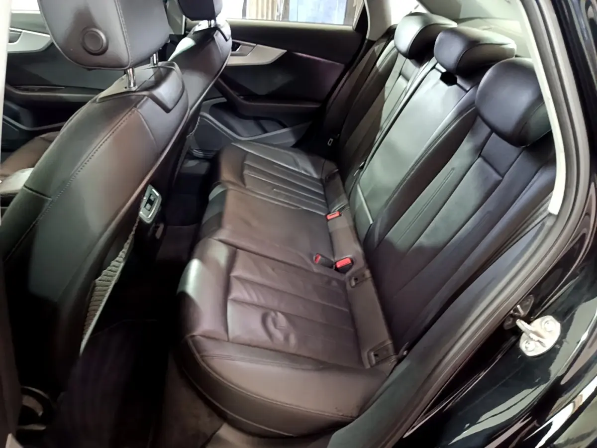 Vue intérieure côté droit des sièges arrière en cuir noir de l'Audi A4 40 TDI 2018 avec appuie-têtes réglables.