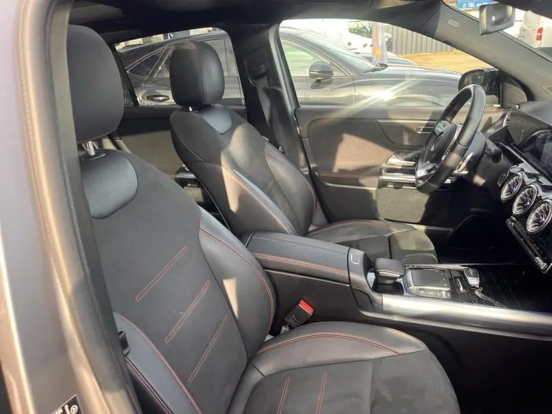 Vue intérieure côté conducteur du Mercedes GLA 200 d AMG Line 2021 avec sièges sport noirs et surpiqûres rouges.