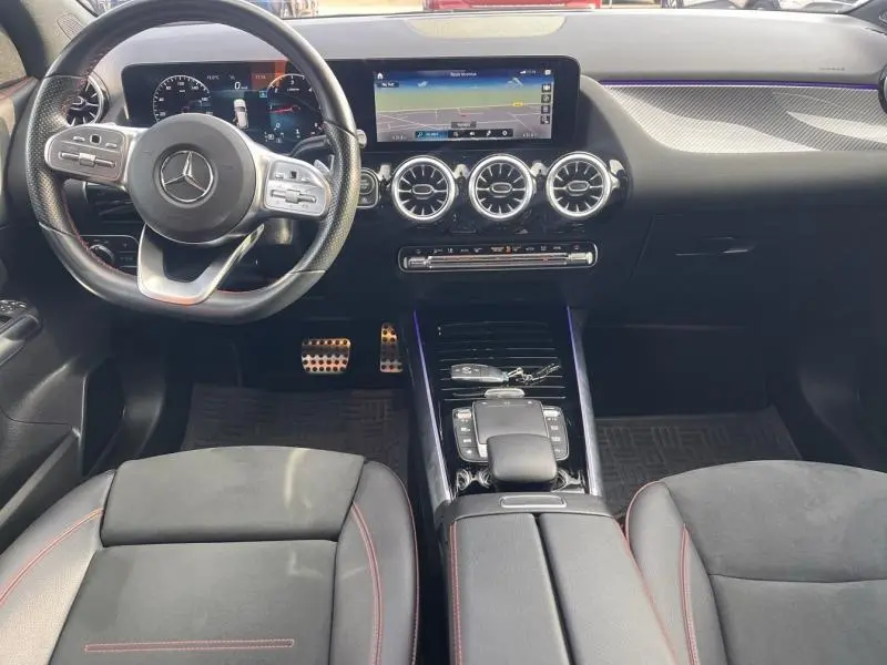 Vue intérieure avant du Mercedes GLA 200 d AMG Line 2021, volant cuir multifonction et écran tactile central.