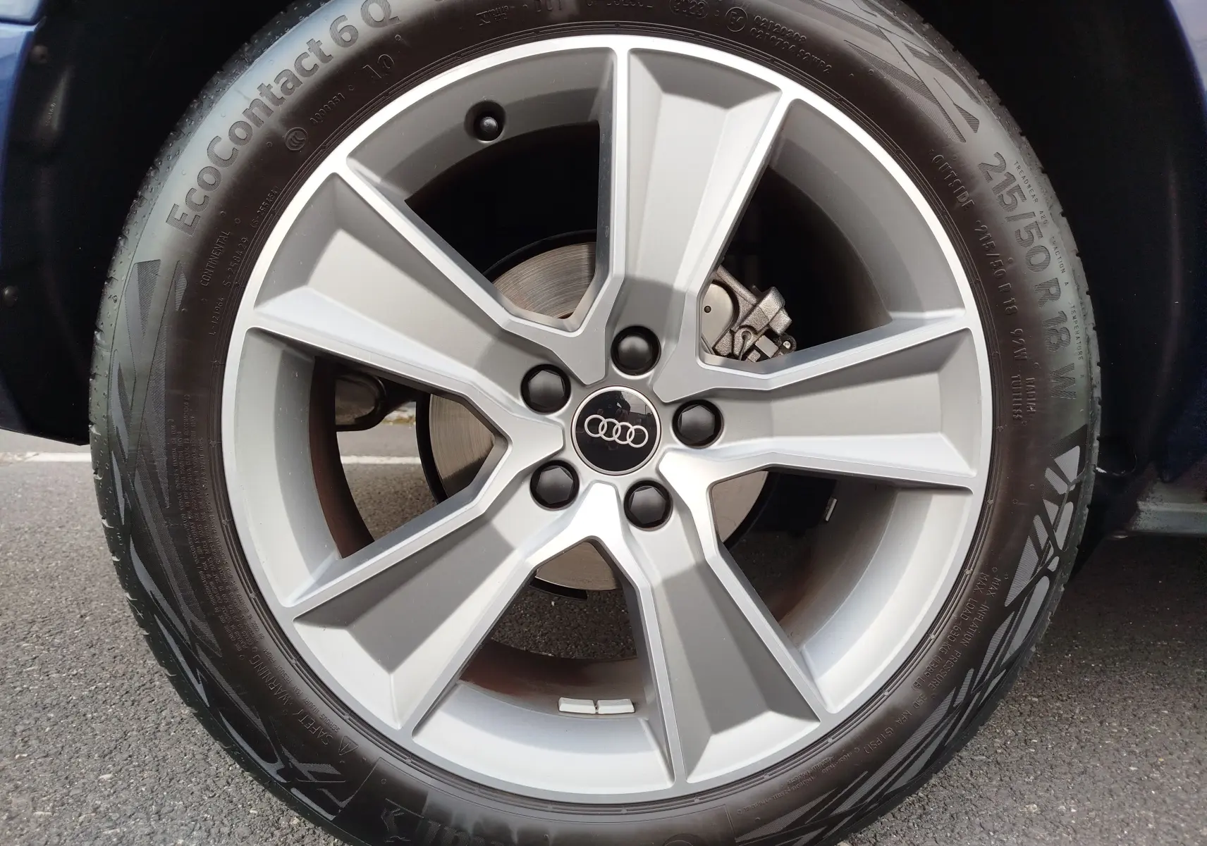 Gros plan sur la jante alliage 18 pouces et pneu Continental d’un Audi Q2 bleu Navarre, version 35 TFSI S line.